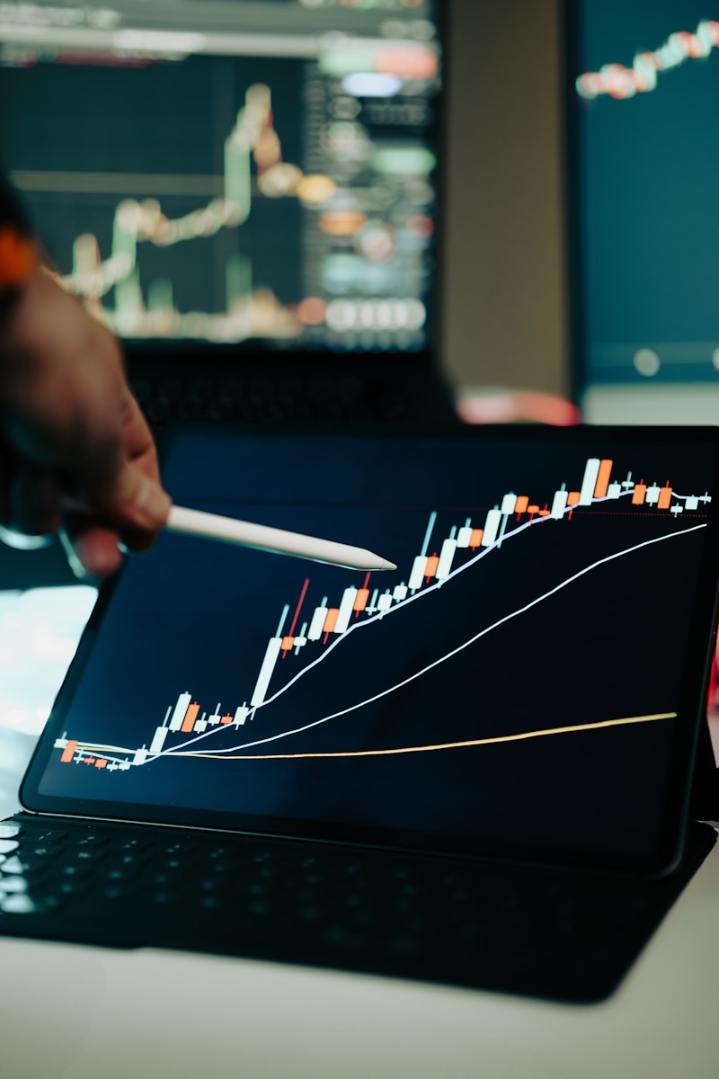 A person pointing at a chart on a laptop